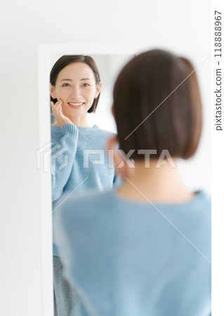 A middle woman watching a mirror A middle woman watching a mirror 118888967