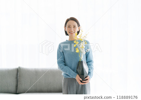一位 30 多歲的女士用鮮花裝飾她的房間 118889176