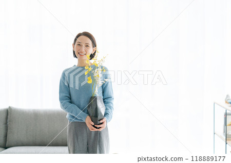 A woman in her 30s decorating her room with flowers 118889177