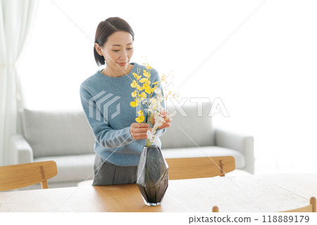 一位 30 多歲的女士用鮮花裝飾她的房間 118889179