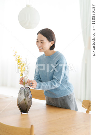 一位 30 多歲的女士用鮮花裝飾她的房間 118889187
