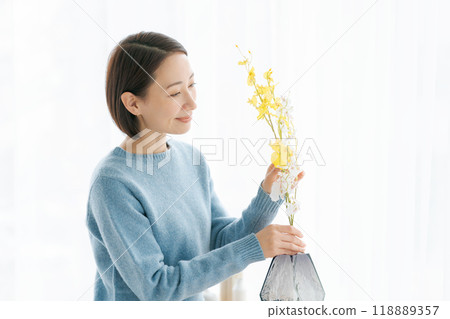 一位 30 多歲的女士用鮮花裝飾她的房間 118889357