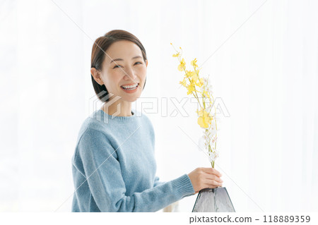 一位 30 多歲的女士用鮮花裝飾她的房間 118889359