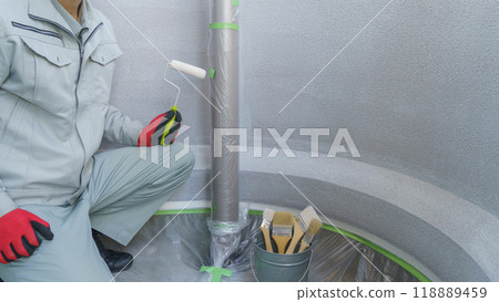 Image of exterior wall painting | A worker painting an exterior wall cured with a masker 118889459