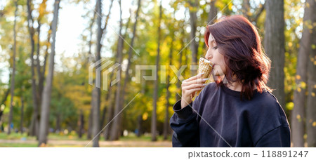refreshing taste of ice cream brings a smile to the face of a female figure as she licks the frozen confection in a serene outdoor locale 118891247