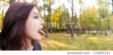 Captured in a close-up, a confident teen extends her tongue to reveal a fresh body modification 118891252