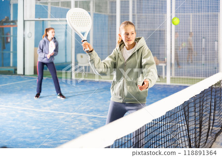 Girl tennis player playing padel tennis 118891364
