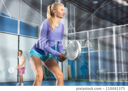 Woman with racquet playing padel 118891375