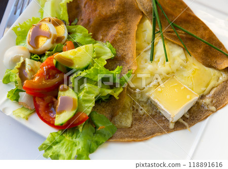 Pancake with melted cheese and salad from fresh vegetables Pancake with melted cheese and salad from fresh vegetables 118891616