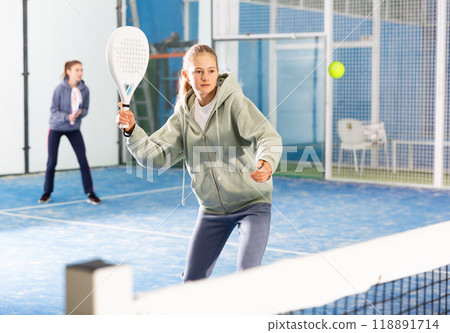 Young girl with racquet playing padel Young girl with racquet playing padel 118891714