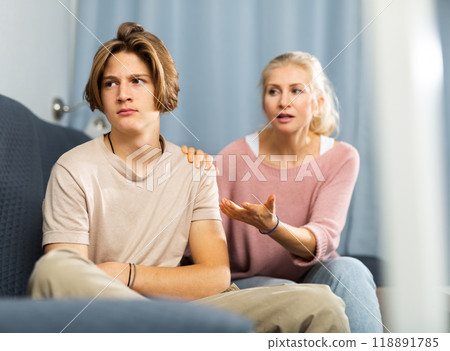 Friendly caring woman calming sad teenage son at home Friendly caring woman calming sad teenage son at home 118891785