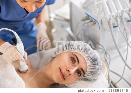 Female client undergoing anti-aging ultrasonic phonophoresis procedure on decollete 118891846