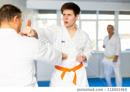 Adult and young men training karate fight Adult and young men training karate fight 118891968