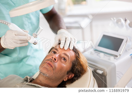 European man undergoes facial skin moisturizing procedure with hydrogen-oxygen hydrating nozzle European man undergoes facial skin moisturizing procedure with hydrogen-oxygen hydrating nozzle 118891979