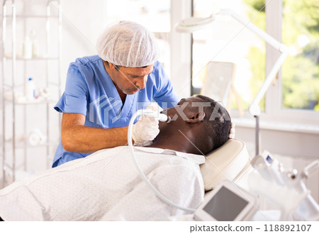 Specialist administers cosmetic treatment 118892107