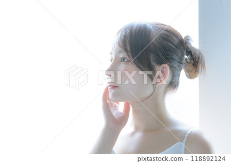 A young woman taking care of her skin in the morning sun 118892124