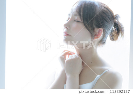 A young woman taking care of her skin in the morning sun 118892127