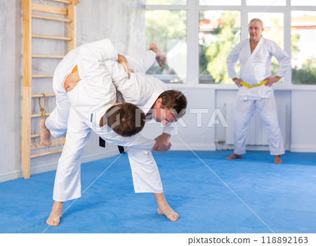 Adult and young men training judo fight Adult and young men training judo fight 118892163