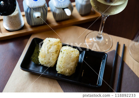 Image of tasty triangular onigiri from rice at black plate 118892233