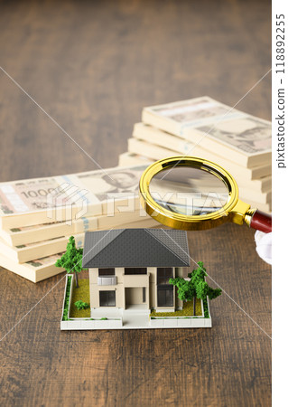 A miniature house and a stack of new banknotes (+magnifying glass) A miniature house and a stack of new banknotes (+magnifying glass) 118892255
