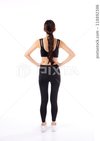 Portrait of beautiful young asian woman in sportswear showing waist and abs isolated. 118892386