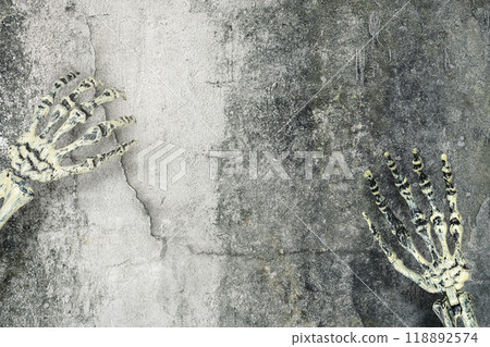 Human skeleton hand reaching out in wall, with a creepy, dark and scary mood. The skeleton hand appearing to be a devil, evil, satan, zombie or a monster hand 118892574
