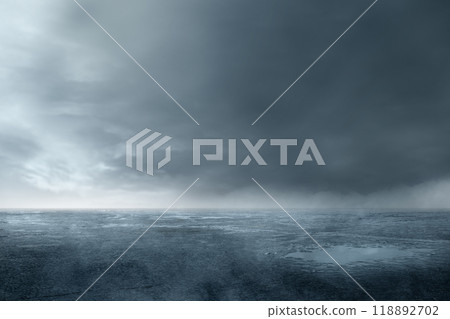 A wet, muddy field with cloudy and dark sky background 118892702