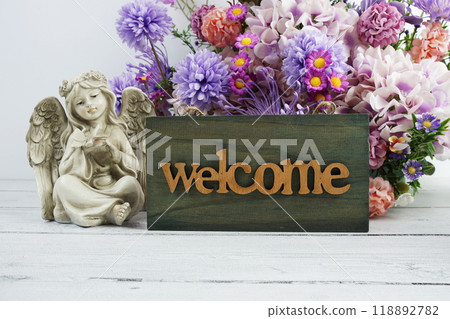 Welcome sign with flowers bouquet and angel statues home decorations Welcome sign with flowers bouquet and angel statues home decorations 118892782