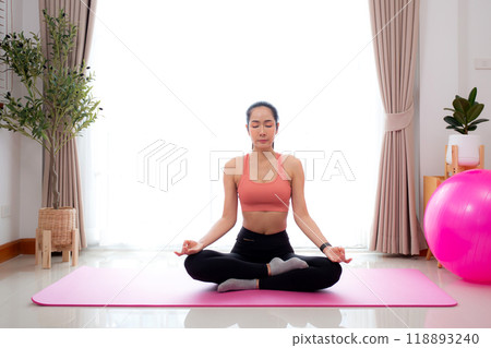 Young asian woman meditation sitting on mat in serene and tranquility with yoga posture lotus. 118893240