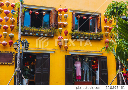 facade of an ancient Asian house decorated with colorful hanging Chinese lanterns for a holiday in old town in Hoi An in Vietnam 118893461