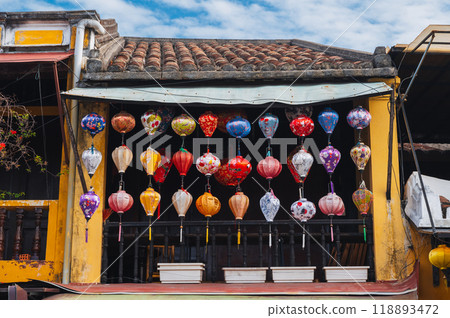 Colorful silk Chinese lanterns decorate the wall of a house for a holiday in old town in Hoi An in Asia 118893472
