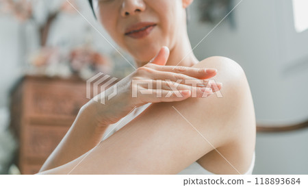 A woman applying body cream to her upper arms A woman applying body cream to her upper arms 118893684