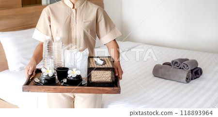 The hotel housekeeper in uniform is preparing equipment for use in the bedroom 118893964