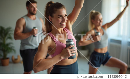 Young sporty woman with bottle of protein shake at home doing stretching exercise  118894042