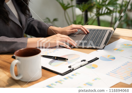 Businesswoman analysis the graph with laptop at the home office for setting challenging business goals And planning to achieve the new target Businesswoman analysis the graph with laptop at the home office for setting challenging business goals And planning to achieve the new target 118894068