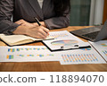 Businesswoman hand holding pen, analysis the graph with laptop at the home office for setting challenging business goals And planning to achieve the new target 118894070