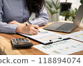 Businesswoman hand holding pen, analysis the graph with laptop at the home office for setting challenging business goals And planning to achieve the new target 118894074