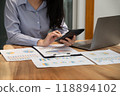 Businesswoman hand holding pen, analysis the graph with laptop at the home office for setting challenging business goals And planning to achieve the new target 118894102