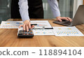 Businesswoman hand holding pen, analysis the graph with laptop at the home office for setting challenging business goals And planning to achieve the new target 118894104
