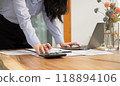 Businesswoman hand holding pen, analysis the graph with laptop at the home office for setting challenging business goals And planning to achieve the new target 118894106