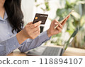 Consumer woman hand holding a mock up credit card, ready to spending pay online finance shopping according to discount products via smart phone from home office 118894107