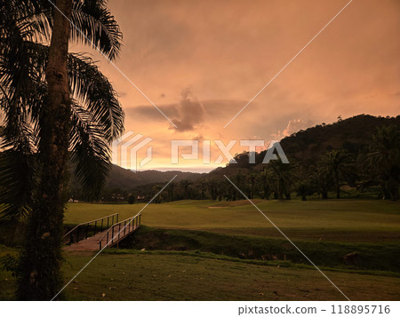sunset in the tropics among palm trees with a bridge clouds 118895716