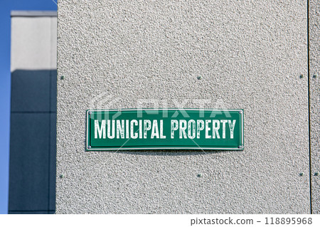 Municipal Property. Green street name plate on the wall of the building Municipal Property. Green street name plate on the wall of the building 118895968