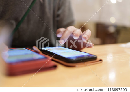 A woman playing a game on her smartphone A woman playing a game on her smartphone 118897203