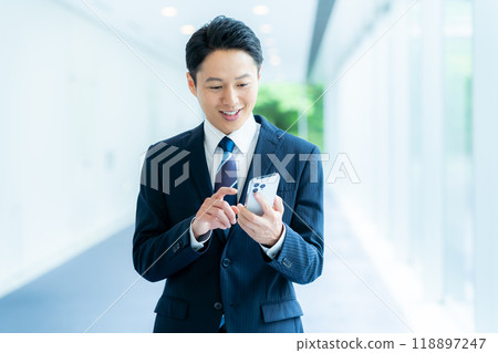 商人在辦公室走廊操作智慧型手機 118897247
