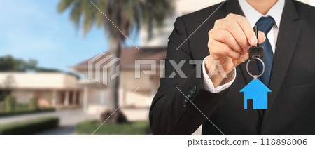 Real estate agent handing over house keys in hand 118898006