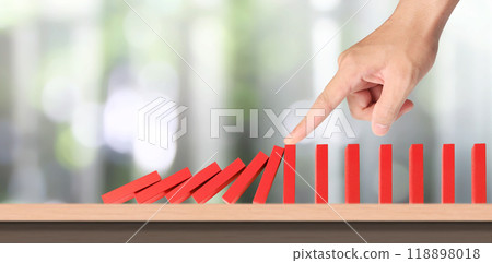 Hand stopping the Domino effect stopped by unique grass as fokaw 118898018