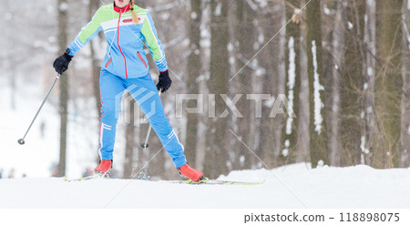 Skiing in a snowy forest during winter with vibrant activewear Skiing in a snowy forest during winter with vibrant activewear 118898075