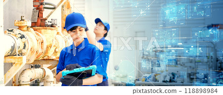 Engineers inspecting factory machinery and piping with digital technology Horizontal visual for banners and advertisements 118898984