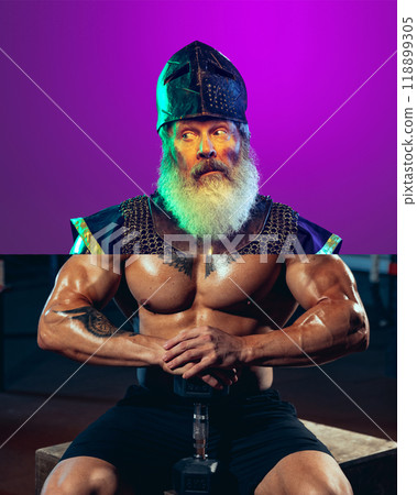 Knight bodybuilder. Creative collage. Elderly bearded man in medieval knight helmet and armor with shirtless male muscular body and dumbbells Knight bodybuilder. Creative collage. Elderly bearded man in medieval knight helmet and armor with shirtless male muscular body and dumbbells 118899305